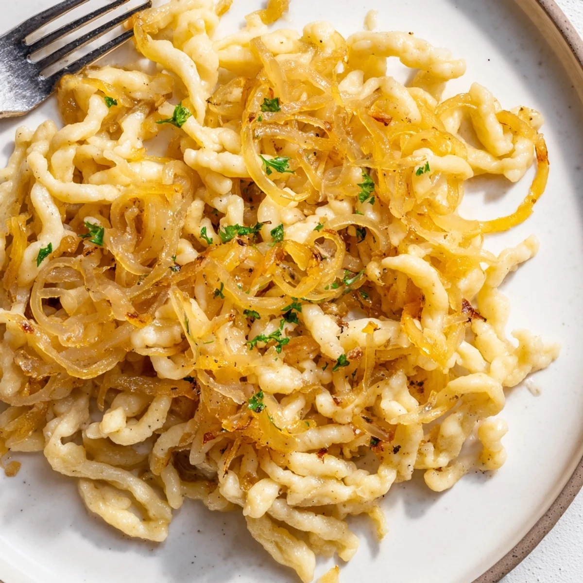 Zarte Spaetzle mit süßen, karamellisierten Zwiebeln für die perfekte Beilage.  