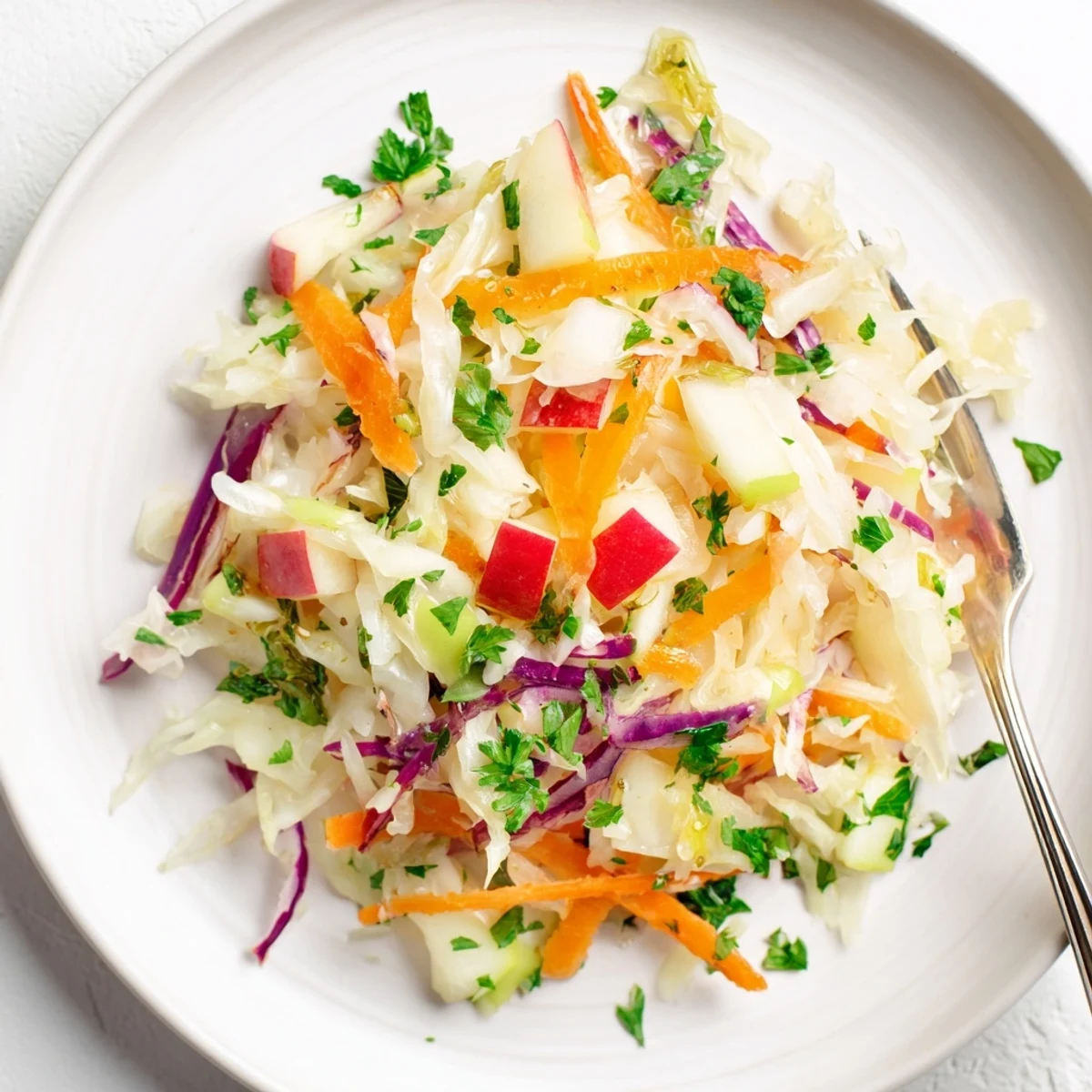 Frischer Sauerkraut-Salat mit knackigen Äpfeln und aromatischen Kräutern als Beilage.