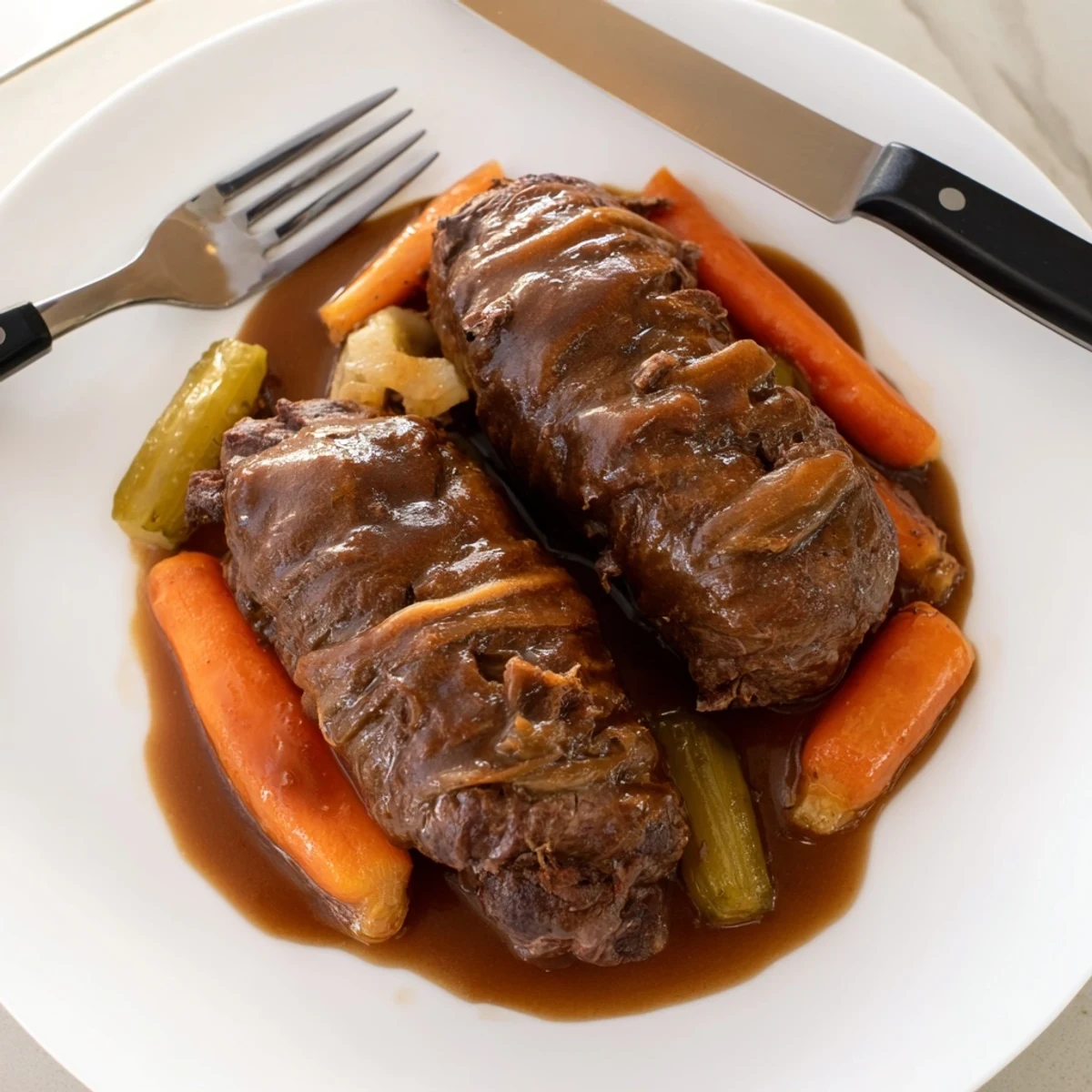 Zarte Rinderrouladen gefüllt mit Speck und Gurken, serviert in köstlicher Soße.  