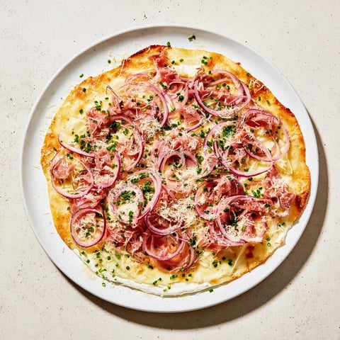 Savory Maultaschen flatbread, crispy and golden, features caramelized onions and creamy cheese beautifully arranged.