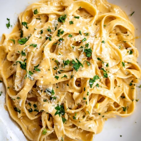 Geschmackvolle Sriracha-Honig-Pasta liegt neben einer Glasweinflasche auf einem rustikalen Tisch für eine herbstliche Mahlzeit.  