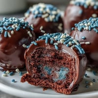 Kuchen-Pop-Klassiker in Schulfarben: Feuchte Kuchenkrümel mit cremiger Glasur geformt, in bunten Schokoladenüberzug getaucht und festlich dekoriert.